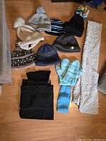 Overview of all items in the set showing 7 toques, mittens, scarf and neck warmers