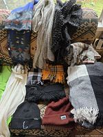 Overview of all scarves and two toques arranged on a patterned fabric surface