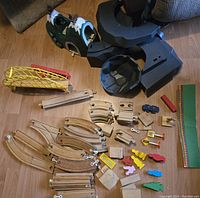 Overhead view of all items arranged on the floor including mountain, bridge, train tracks, figures, and small accessories.
