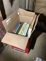 Box filled with seven gardening books, shows book spines and box condition.