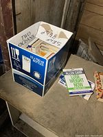 Image of a box filled with books labeled 'Self Help' revealing part of the collection