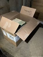 Closed cardboard box filled with gardening books stacked horizontally and vertically.