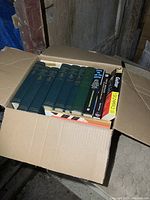 Open box with multiple Groves Dictionary of Music and Musicians volumes and other music books.