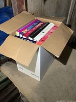 Box of books showing the tops and spines of various books