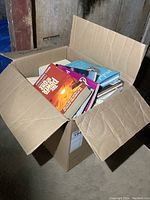 Box filled with various books showing condition and quantity