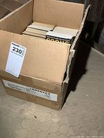 Photo of box full of novels packed vertically, showing some spines