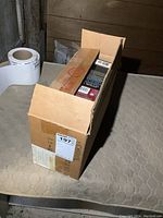 Cardboard box containing multiple Star Wars books stacked vertically inside.