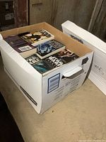 Box full of Star Wars books with visible covers featuring Star Wars characters and titles.
