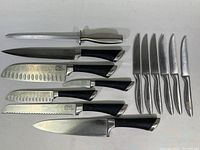 Full layout of the set: sharpening steel, seven kitchen knives with black handles, and six steak knives with metal handles.