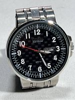 Close-up of the watch face showing black dial, white Arabic numerals, day-date window at 3 o'clock, and Citizen Eco-Drive branding.