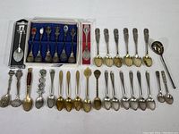 Full view of entire spoon collection laid out including boxed sets and loose spoons