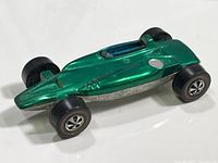 Top and angled view of the metallic green Hot Wheels Shelby Turbine car showing blue windshield and redline wheels.