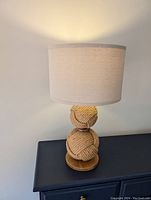 Full view of lamp showing two balls of rope and lampshade