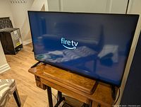 Front view of TV powered on showing ‘fire tv’ screen