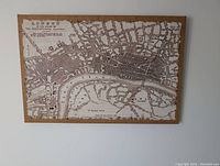 Full view of the London map showing the streets and river on coarse canvas with wooden frame.