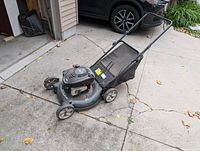 Photo showing the full view of the Quantum XRQ petrol lawn mower on a driveway with grass catcher attached.