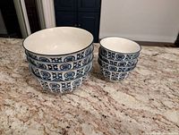 Stacked view of 4 large and 4 small matching bowls showing blue and white patterning and size comparison.