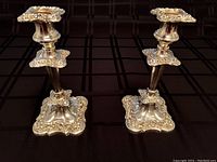 Pair of vintage silverplated candlesticks showing front angle, matching designs and size