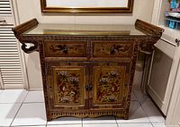 Front view of painted cabinet showing two upper drawers and two lower doors with bird and floral motifs