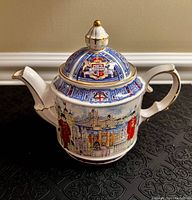 Front and side views showing detailed London landmarks and guards with blue and gold decorative lid