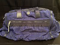 Front view of dark blue Lululemon gym duffle bag showing zipper, handles, and logo.