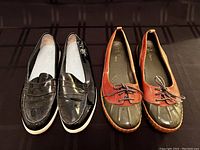 Side-by-side view of both pairs of shoes: black patent leather loafers and brown/green waterproof duck shoes