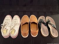 All three pairs of shoes in the lot: Converse sneakers, UGG loafers, and Mephisto sandals on a dark surface.
