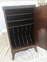 Front view of one cabinet open, showing two shelves and vertical dividers for records.