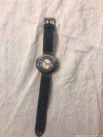 Full view of the 1972 Caravelle Bahamas men's wristwatch with black strap laying flat.