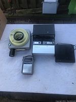 Electronic lot arranged on a white surface: 2 slide projectors, DVD player, GE transistor radio