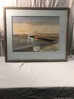 Frontal view of the framed watercolour painting depicting Howth Harbour with boats and quay under soft light.