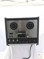 Front view of TEAC 2300S reel to reel tape recorder showing dual reel spindles, controls and meters.