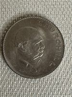 Obverse side of the coin showing Winston Churchill in profile with the inscription 'CHURCHILL'.