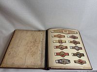 Open view of album showing multiple pages with vintage cigar bands adhered