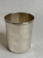 Full view of the sterling silver cup showing smooth, slightly reflective surface and rounded lip.