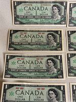 Close-up view of individual vintage Canadian one dollar bill featuring Queen Elizabeth II and Centennial of Canadian Confederation details.