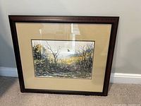Framed artwork of a bird flying over a winter landscape, showing bare trees and a serene sky.