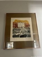 Framed artwork showing a girl seated at a piano from behind, with a warm color background and sheet music details.