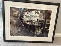 Photo of framed artwork showing an old man seated in a rustic workspace with window light, surrounded by tools and household items, the piece titled "Charlie's World" by Mel Crawford.