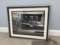 Photo of framed black and white print showing interior of a theater, seating and stage area visible