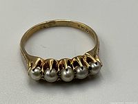 Top view of 14k yellow gold ring with five pearls