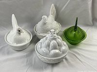 Four covered dishes displayed on white backdrop