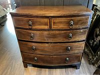 Full front view of dresser showing serpentine profile, five drawers, crossbanded top.