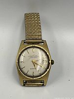 Front view of watch face and expandable bracelet showing dial, markers, hands, and date window