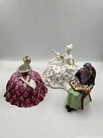 Three Royal Doulton figurines together showing size and design variety