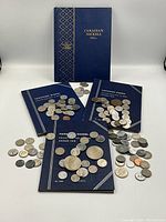 Four navy blue coin books titled 'Canadian Nickels 1922' and one titled 'Canadian Nickel Collection 1962' with various Canadian nickel coins arranged on and around the books.