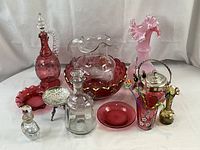 Front view of all glassware items including decanter, pitcher on bowl, stir sticks in lidded jar, vases, and small dishes.