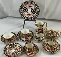 All 13 pieces arranged on table with plate on easel