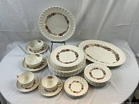 Full lot overview showing plates, cups, saucers and bowls arranged on white cloth.