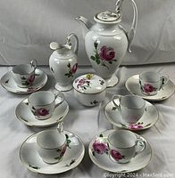 Front view of entire tea set arranged, including teapot, cups, saucers, creamer, sugar bowl